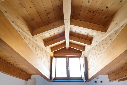 a large wooden ceiling in a room with a window at Don Giulio Luxury Home jacuzzi in Vico Equense