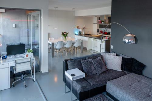 a living room with a couch and a desk and a kitchen at London 993 Apt 202 in Antwerp