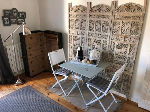 une table et deux chaises dans une pièce avec un mur dans l'établissement La Mulonniere, à Saint-Sébastien-sur-Loire