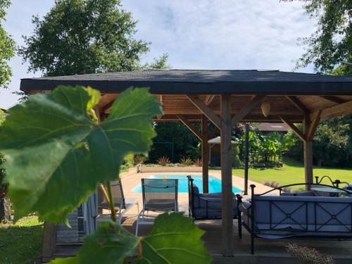 a pavilion with chairs and a swimming pool at Maison d'Hôtes Lassaubatju in Hontanx
