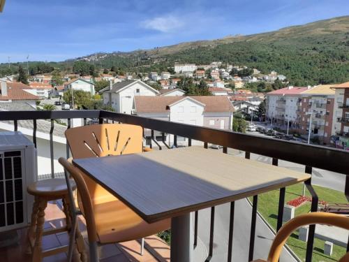 a table and chairs on a balcony with a view at SEIA Alojamentos Leitao in Seia