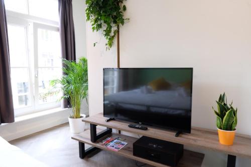 a flat screen tv sitting on a table in a living room at Beautiful 60m2 One-Bedroom Apartment with Terrace - WA7A in Tiel