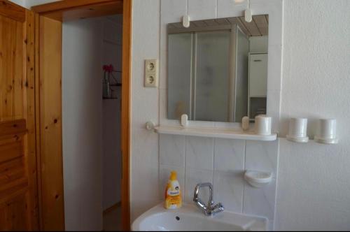 ein Bad mit einem Waschbecken und einem Spiegel in der Unterkunft Ferienhaus Bärbelstein Barbarossa in Erlenbach