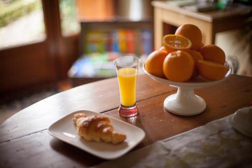 a table with a plate of food and a glass of orange juice at Ferme des Vallees in Soindres