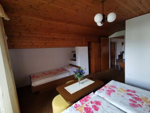 een kamer met 2 bedden en een tafel met bloemen erop bij Apartment Žvab in Bohinj
