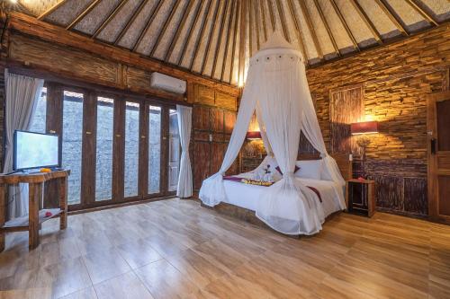 a bedroom with a bed with a canopy at The Forest Villa Ubud in Ubud