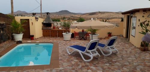a patio with two chairs and a swimming pool at Villa FranyMar in Lajares
