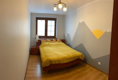 um quarto com uma cama com um mural de montanha na parede em Apartament o Zachodzie Słońca Nadrzeczna em Karpacz