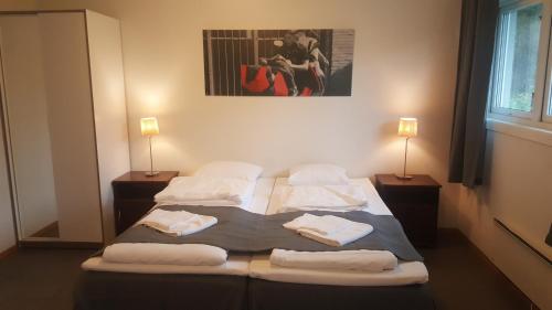 a bedroom with a large bed with towels on it at Motell Svinesundparken in Halden