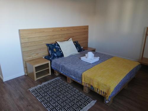 a bedroom with a bed with a wooden headboard at Cabeço das Fráguas - apartamento centro cidade da Guarda in Guarda
