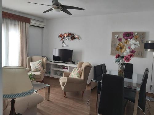a living room with a television and a dining room at Apartamento Cuesta San Judas in Antequera