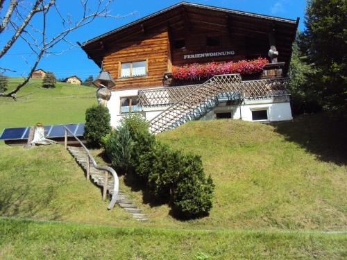 ein Haus auf einem Hügel mit Treppen und Blumen in der Unterkunft Haus Martine in Raggal