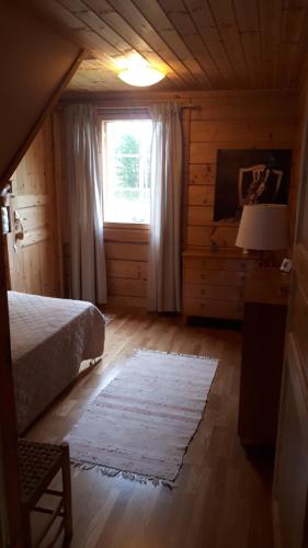 a bedroom with a bed and a window and a rug at Savutaival in Pello
