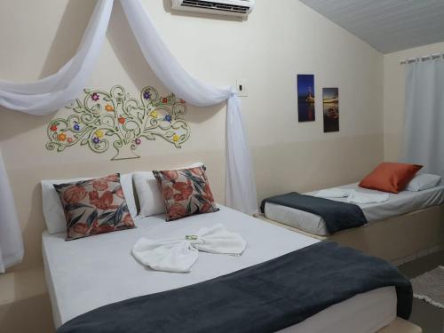 ein Schlafzimmer mit 2 Betten und Handtüchern darauf in der Unterkunft Pousada Dois Rios in Barra do Garças
