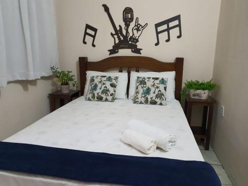 a bedroom with a bed with two towels on it at Pousada Dois Rios in Barra do Garças