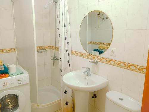 un bagno con lavandino, water e specchio di Apartment Chaparral Complex a Costa Del Silencio