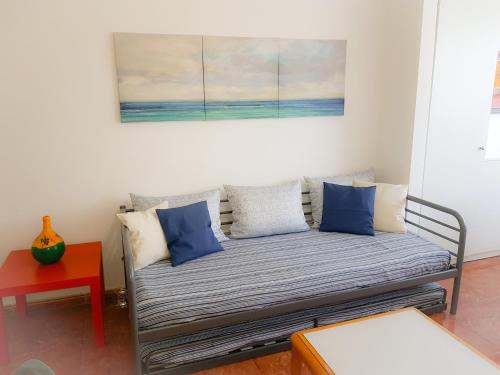 un divano in soggiorno con un dipinto sul muro di Apartment Chaparral Complex a Costa Del Silencio
