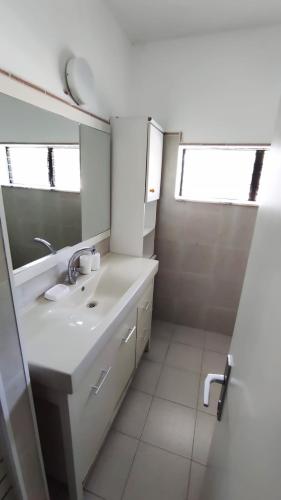 a white bathroom with a sink and a mirror at Guest House "Villa Klara Eilat" Heated pool and sauna all year round in Eilat