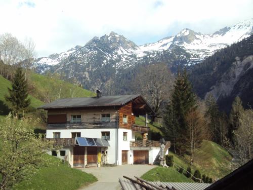 ein Haus auf einem Hügel mit Bergen im Hintergrund in der Unterkunft Haus Martine in Raggal