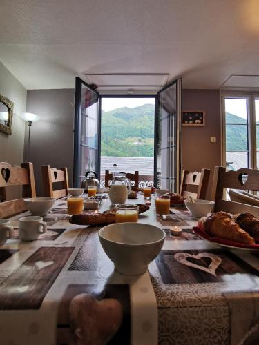 - une grande table en bois avec de la nourriture dans l'établissement Duplex spacieux avec vue montagne au cœur de Cauterets, 6 à 8 pers, 3 chambres, 2 SDB, à Cauterets