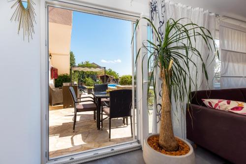 a potted plant sitting next to a sliding glass door at Holiday Home Rosko in Skradin