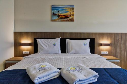 a bedroom with a bed with two towels on it at Hotel Terme Ozren in Bosansko Petrovo Selo