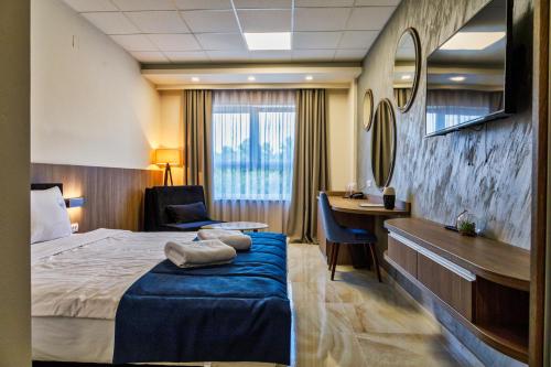Bosansko Petrovo SeloにあるHotel Terme Ozrenのベッドとデスクが備わるホテルルームです。