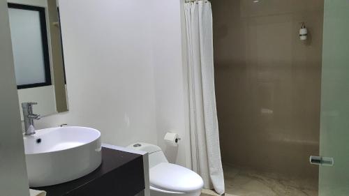 a bathroom with a sink and a toilet and a shower at Nirvana Hotel - Cancun Hotel Zone in Cancún