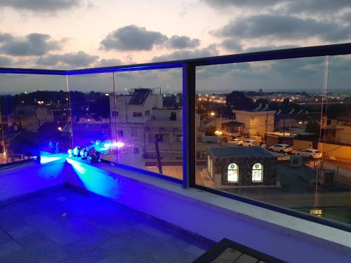 a balcony with a view of a city at night at comft suite Nahariyya in Nahariyya