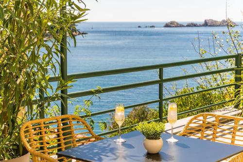 a table with two glasses of wine and a view of the ocean at Art Hotel Dubrovnik in Dubrovnik