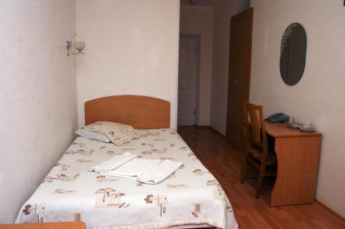 a bedroom with a bed with a table and a chair at Kyiv Hotel in Poltava