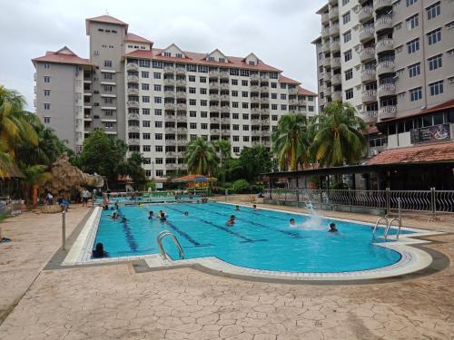a group of people in a swimming pool with buildings at Glory Beach Resort PriVate PentHouse in Port Dickson