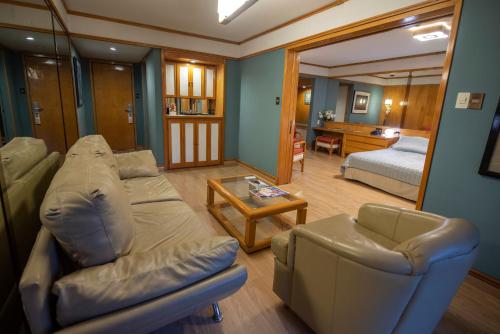 een woonkamer met een bank en een bed bij Hotel Cecilia in Asuncion