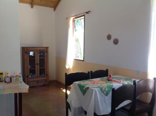 a dining room with a table and a window at Pousada Por do Sol in Sao Jorge