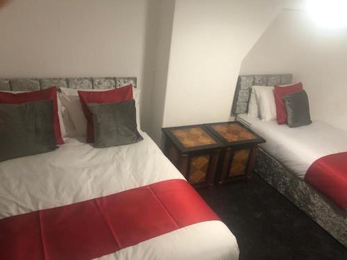 Zimmer mit 2 Betten und einem Beistelltisch in der Unterkunft Kirubash Central Pier Hotel in Blackpool