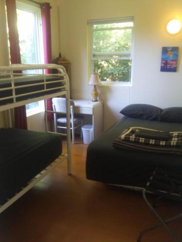 a bedroom with two bunk beds and a desk at C&N Backpackers - Ucluelet in Ucluelet