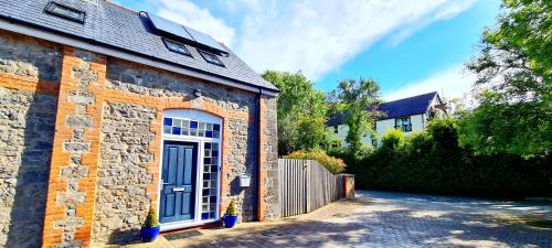 a brick house with a blue door on the side of it at The Old Pump House in Tenby