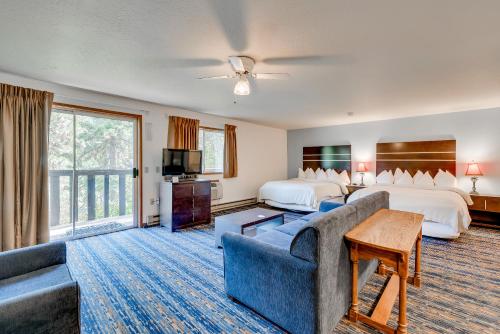 レブンワースにあるAlpine Rivers Innのベッド2台とソファが備わるホテルルームです。