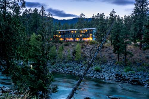 a bridge over a river in front of a building at Alpine Rivers Inn in Leavenworth