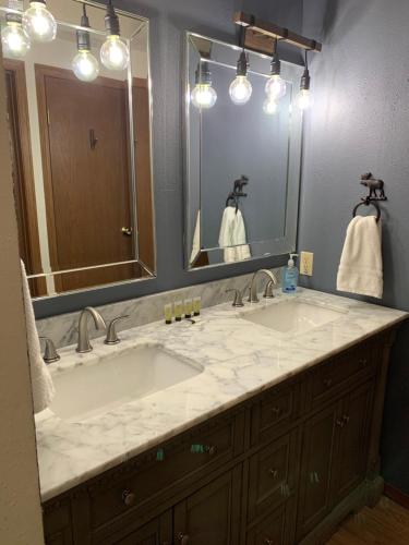 baño con 2 lavabos y espejo grande en Beaver Village Apartment, en Winter Park