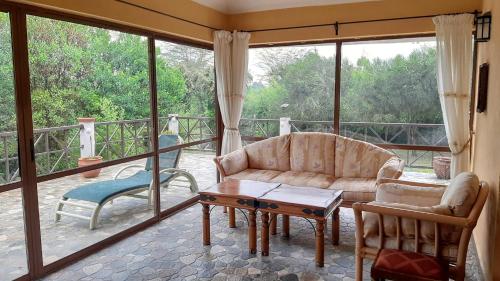 a living room with a couch and a table at Kwezi Cottage at The Great Rift Valley Lodge & Golf Resort Naivasha in Naivasha
