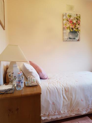 ein Schlafzimmer mit einem Bett und einer Lampe auf einem Tisch in der Unterkunft Hillgrove House in Boyle