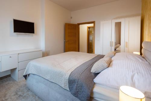 a bedroom with a bed and a tv on the wall at Apartman Mama Donovaly in Donovaly