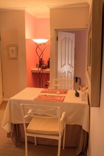 een kamer met een tafel met een stoel en een deur bij Church Hills Boutique Accommodation in Riebeek-Wes