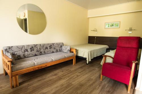 a room with a couch and a bed and a chair at Motelli Rovaniemi in Rovaniemi