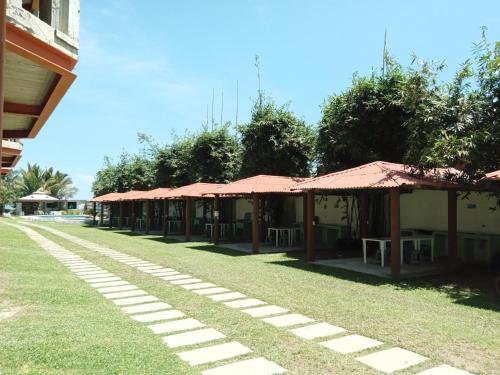 a row of buildings with red roofs on the grass at Hotel La Estrella Polar in Costa Esmeralda