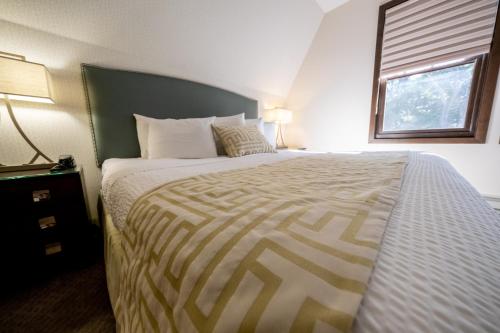 a bedroom with a large bed with a striped bedspread at The Inn at Shattuck - St. Mary's in Faribault