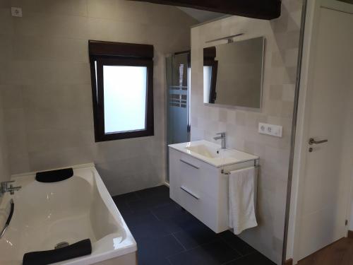 a bathroom with a sink and a bath tub at A xanela in Outes