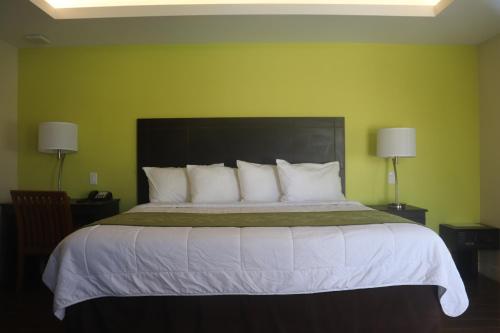 a bedroom with a large bed with white pillows at Curtis Inn & Suites in Hollywood