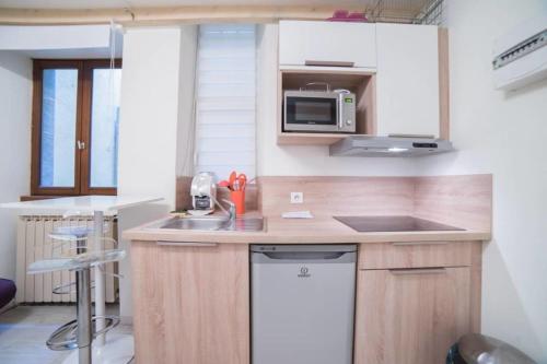 a small kitchen with a sink and a microwave at Le Veyrier - Small studio for 2 people in the heart of the old town in Annecy